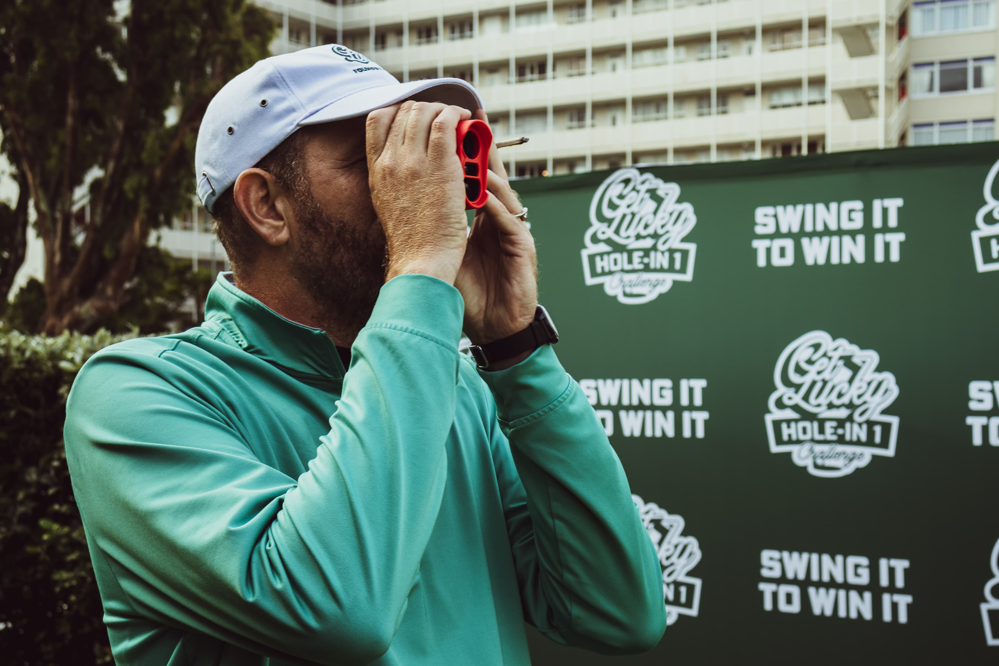 Golfer using a rangefinder at the par-3 challenge