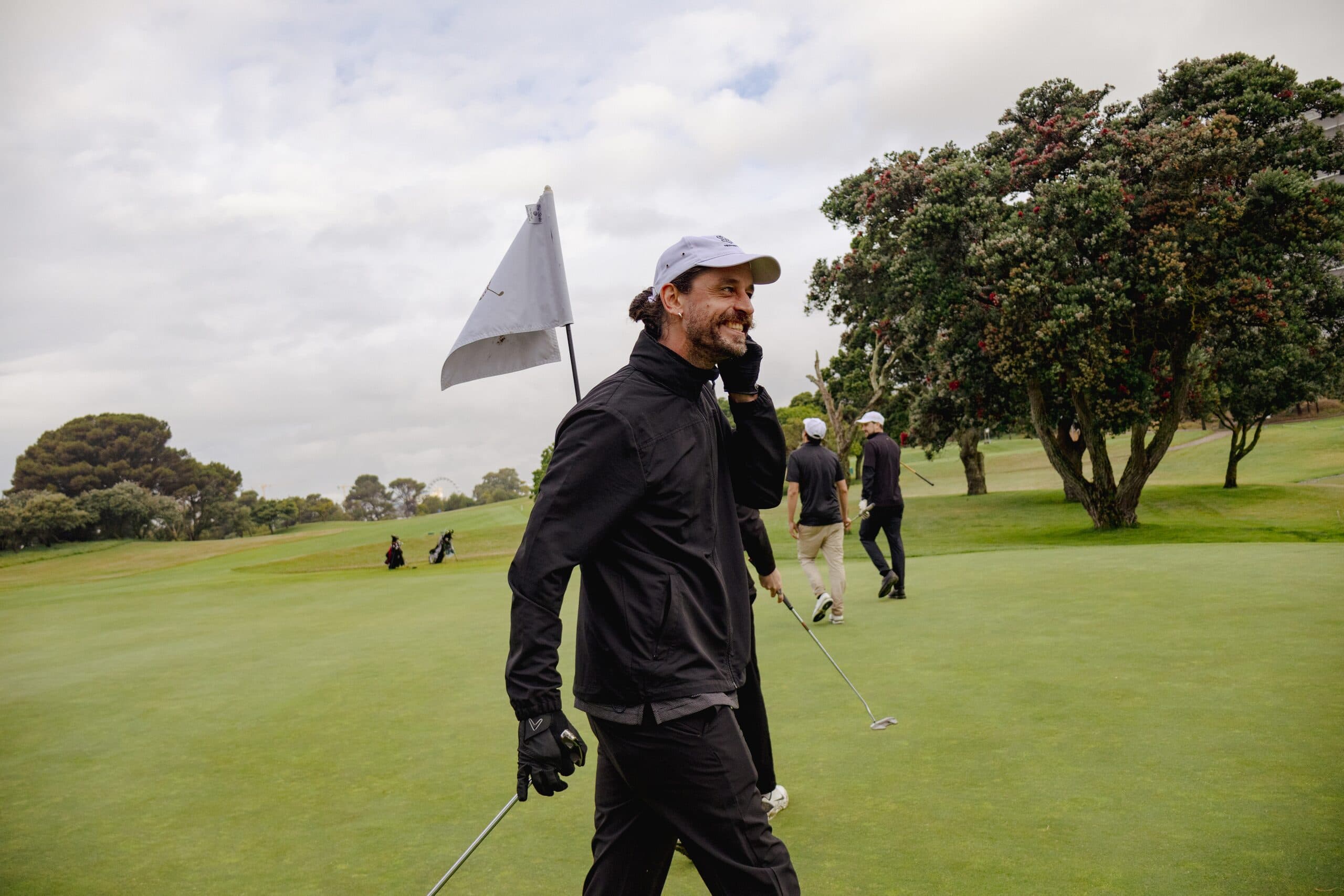 Golfer smiling on the green beside the flag